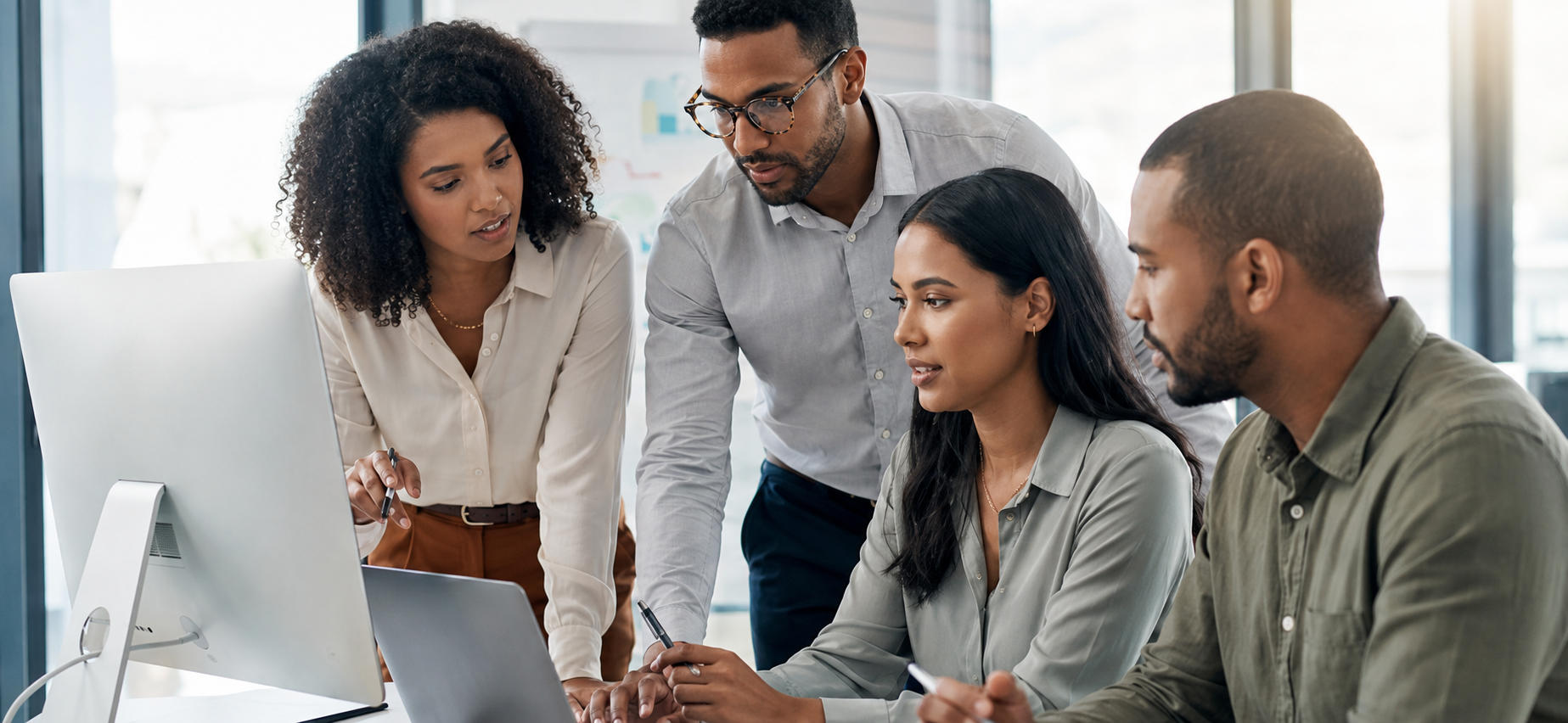 A team of HR professionals reviewing evaluation results together at a monitor